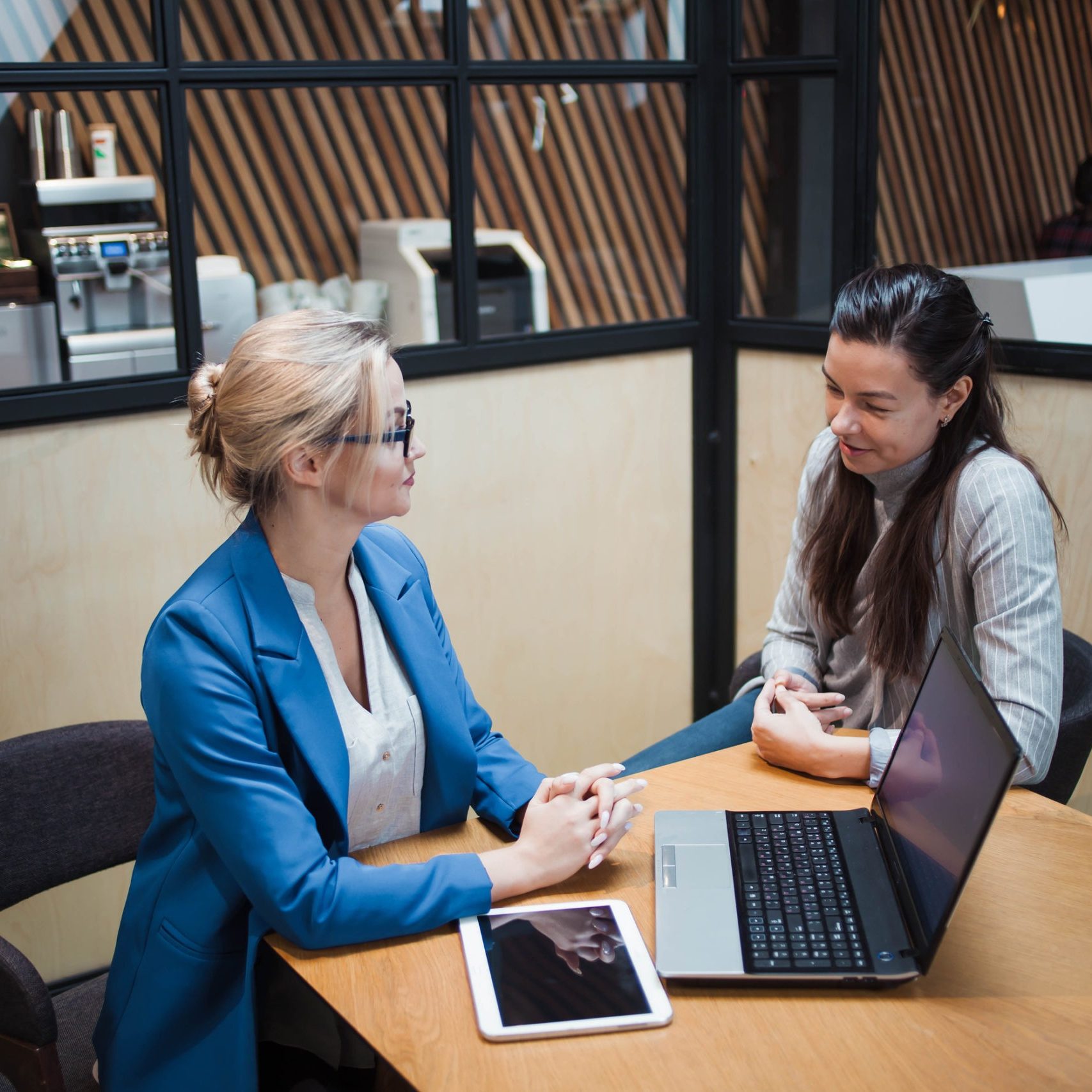 young HR woman interviews a candidate for a job. Business meeting two young women at work discussing the project. Interview with a Manager or job interview, portfolio review
